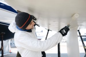 Fleet technician Sam antifouling a yacht at Hamble Point Yacht Charters